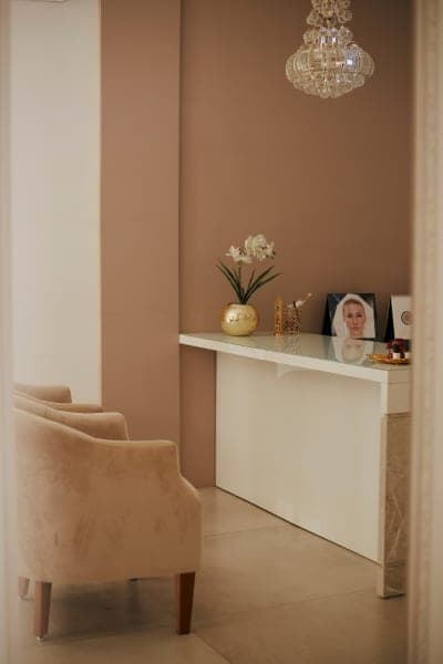 Recepção acolhedora da clínica, com poltrona e iluminação suave